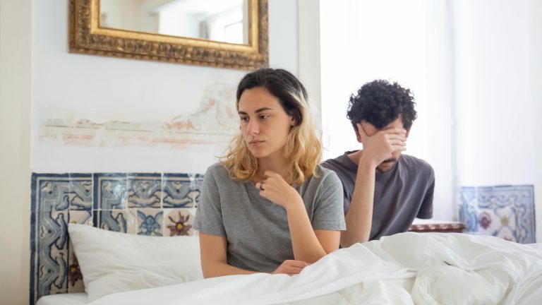 Man with erectile dysfunction sitting with a woman in bed